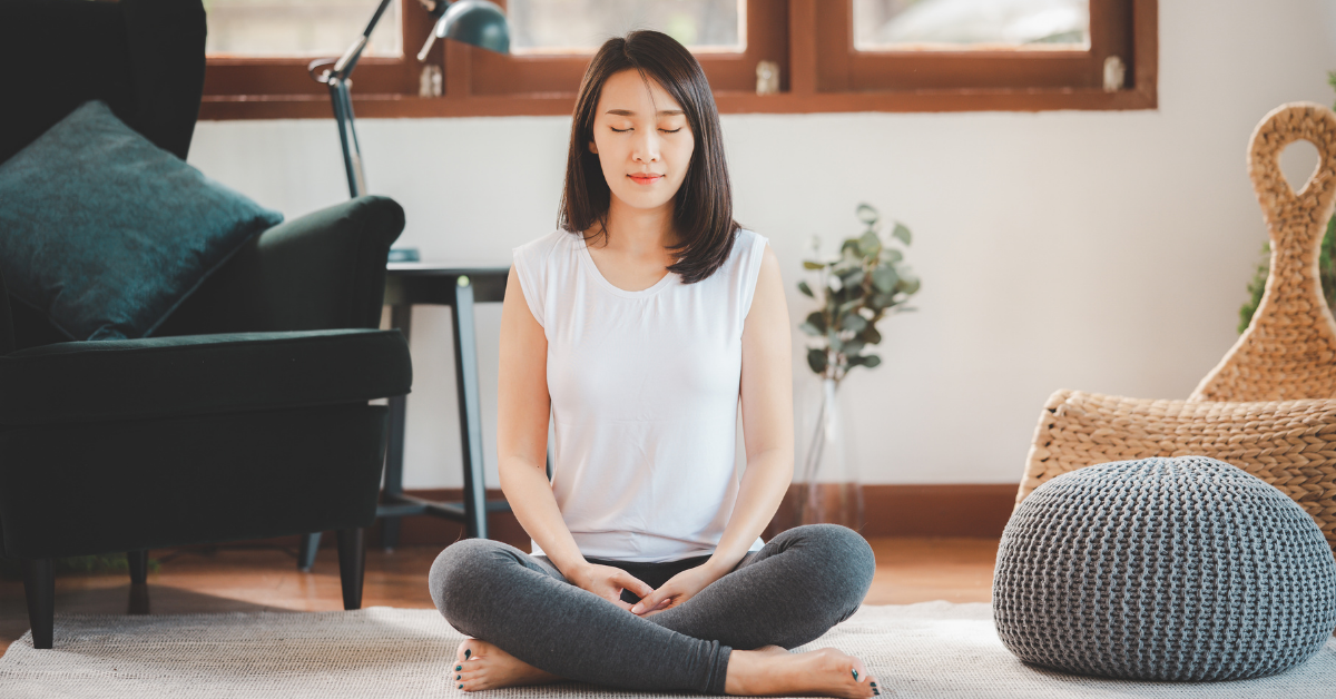 Woman meditating in home living room