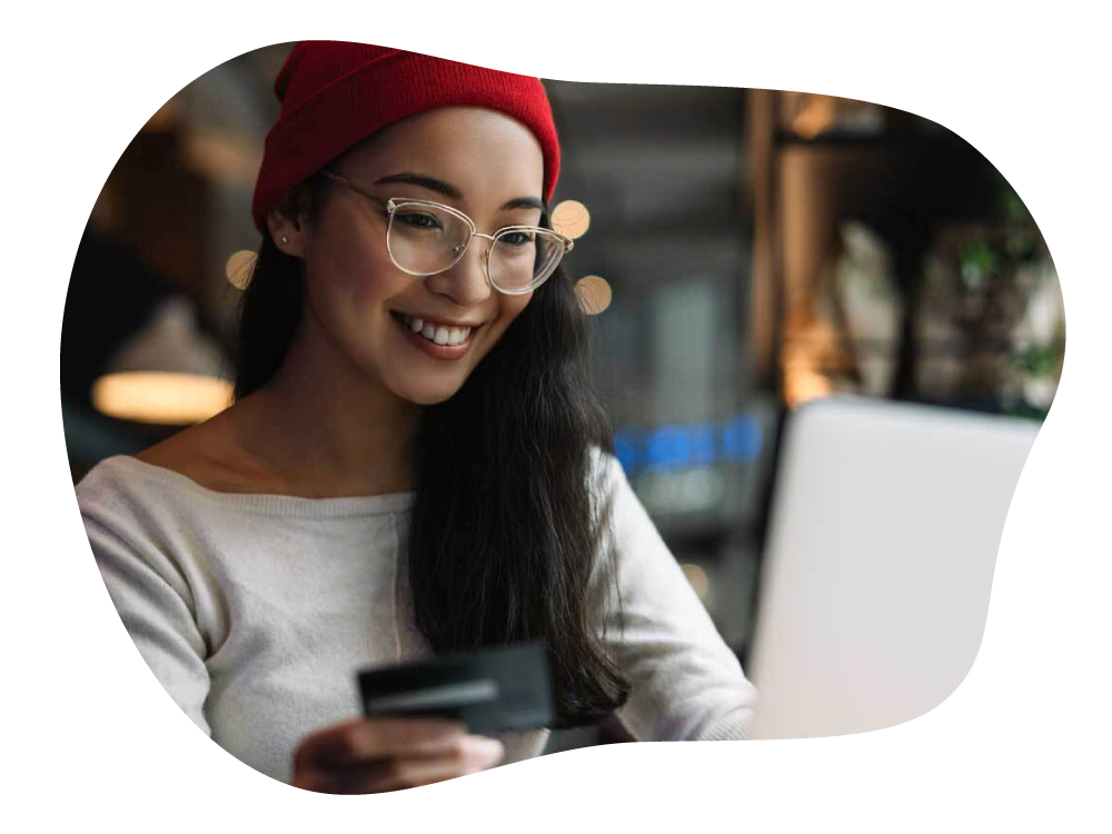 Lady happily making online payment on laptop, with credit card